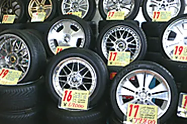 値札の付いたタイヤ・ホイールのセットが並ぶ売り場